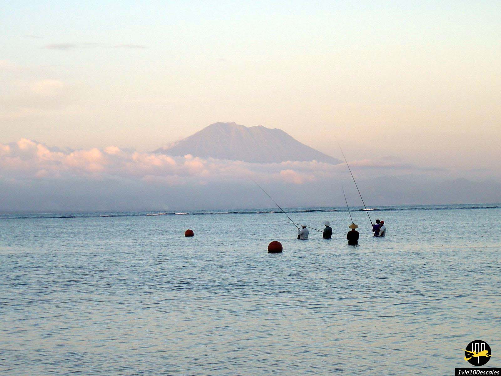 Des pêcheurs balinais dans la mer avec le volcan Mont Batur en arrière plan