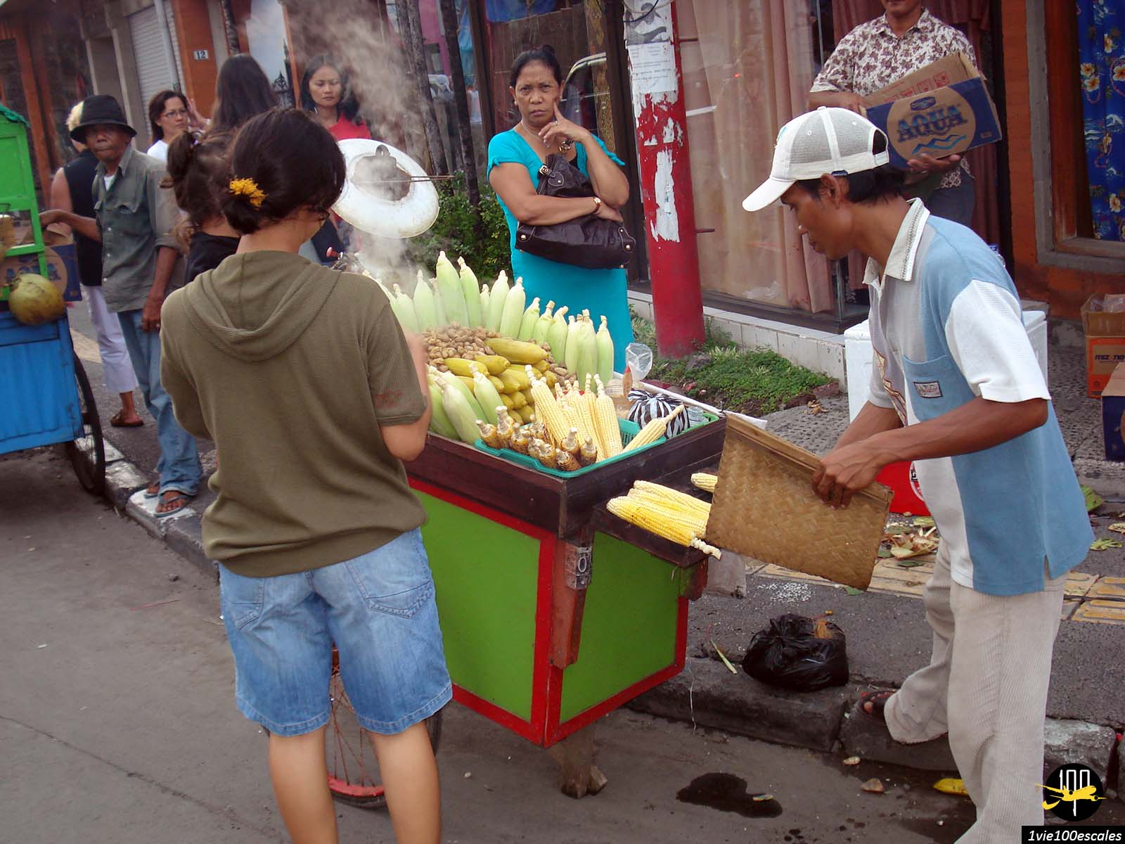 Un marchand ambulant dans les rues de Kuta proposant du blé et du mais chaud