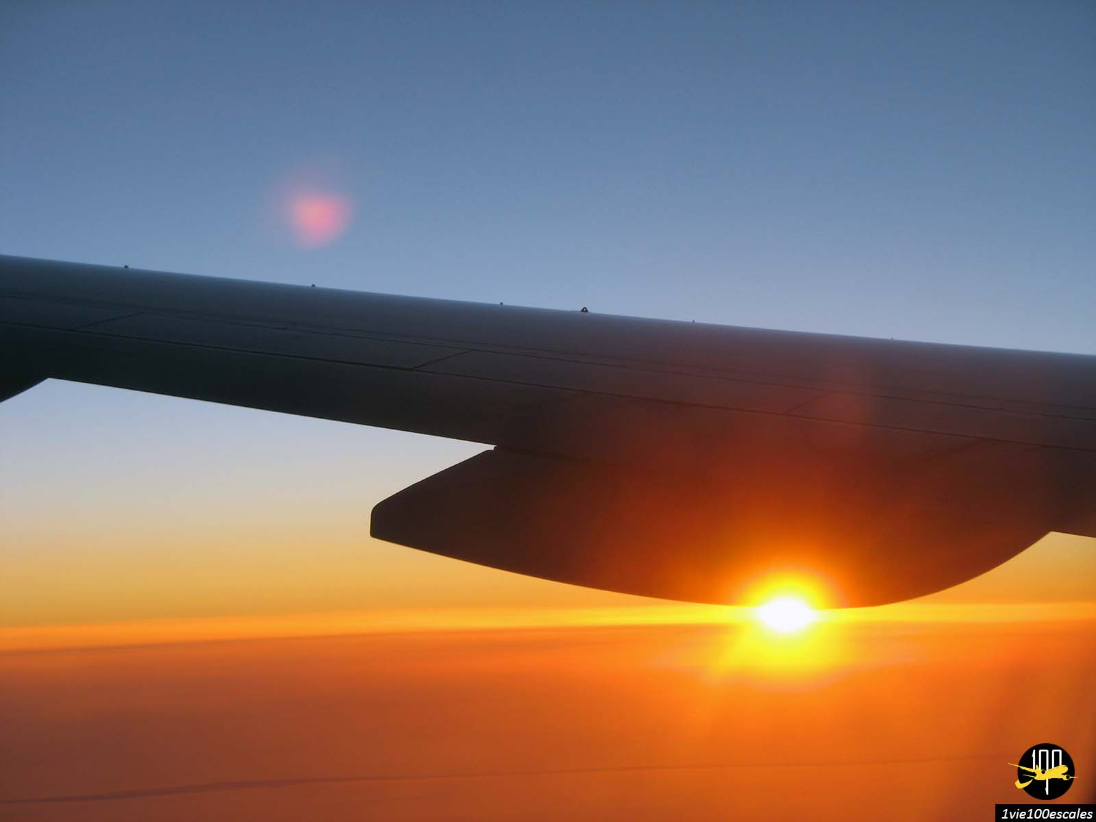 Vue d'un coucher de soleil depuis le hublot dans un vol de la compagnie aérienne Singapore Airlines