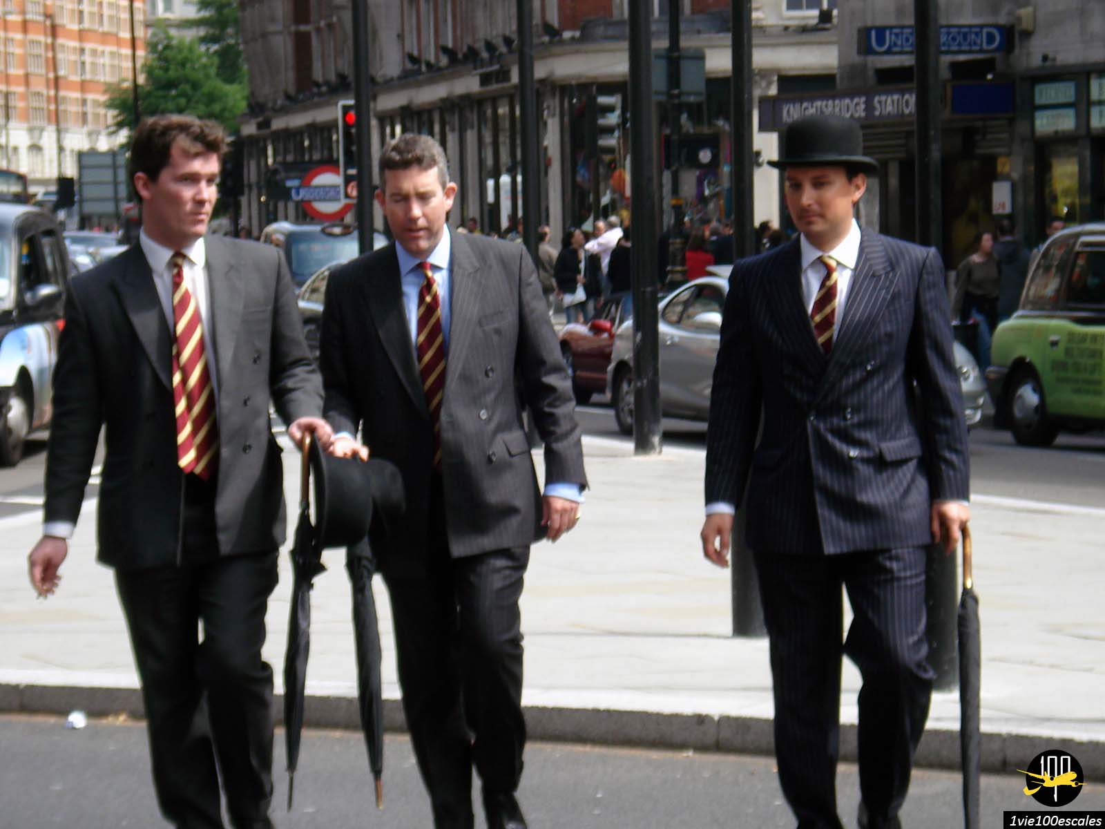 Des hommes d'affaires en costume et chapeau melon avec des parapluies dans les rues de Londres