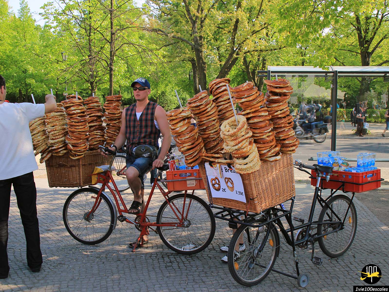 Homme sur le vélo vendant des bretzels devant le Palais du Reichstag de Berlin
