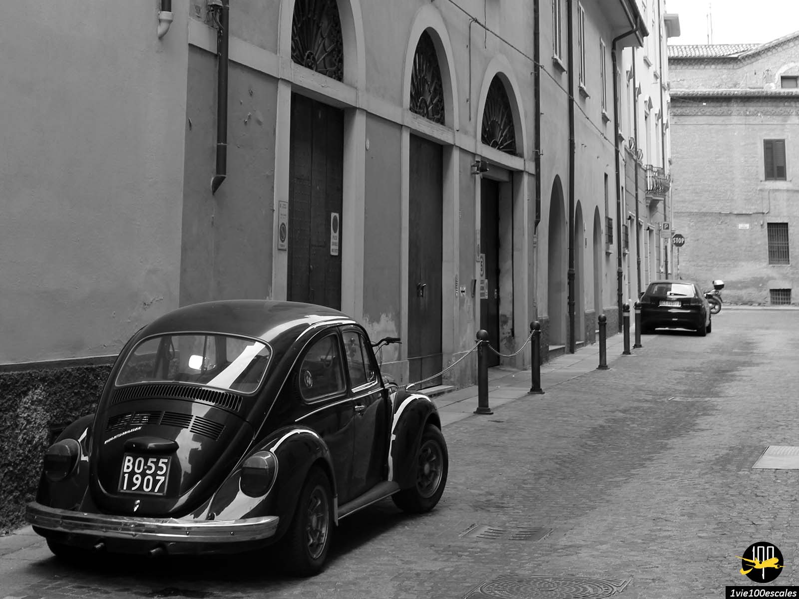 Une photo en noir et blanc d’une coccinelle VW garée dans une rue.