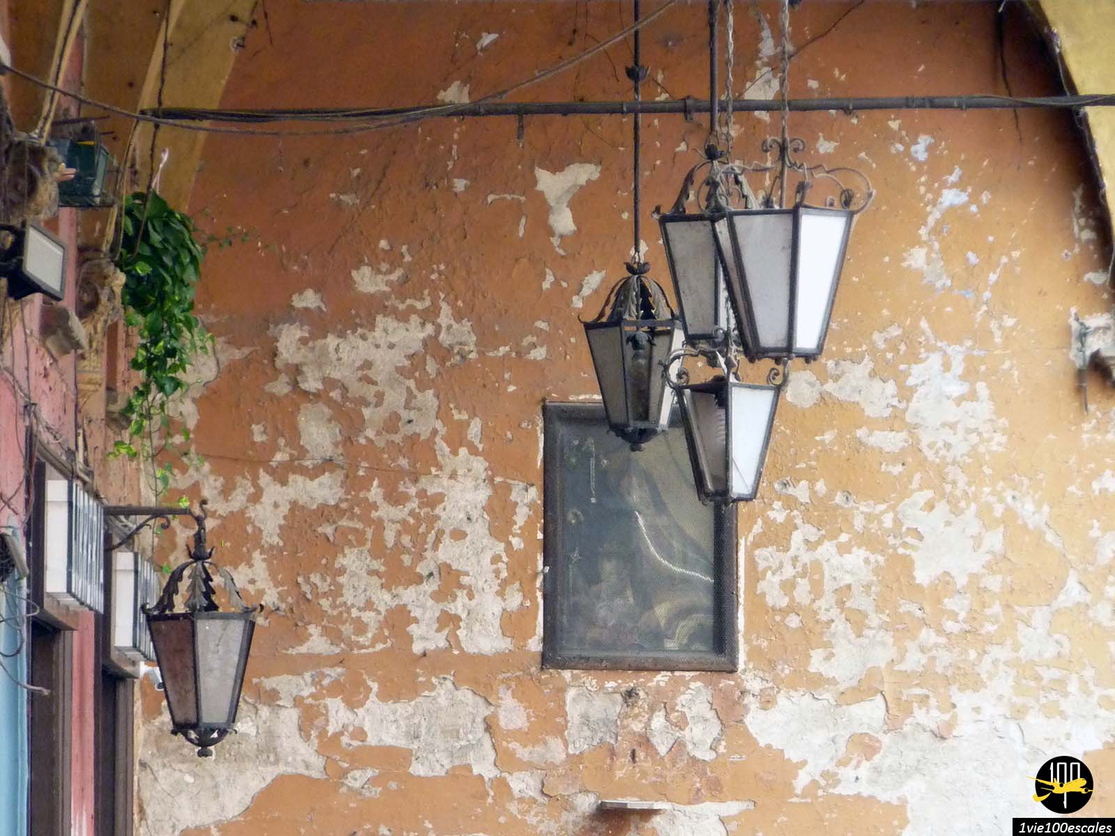 Un groupe de lampes accrochées au mur d’un vieux bâtiment.