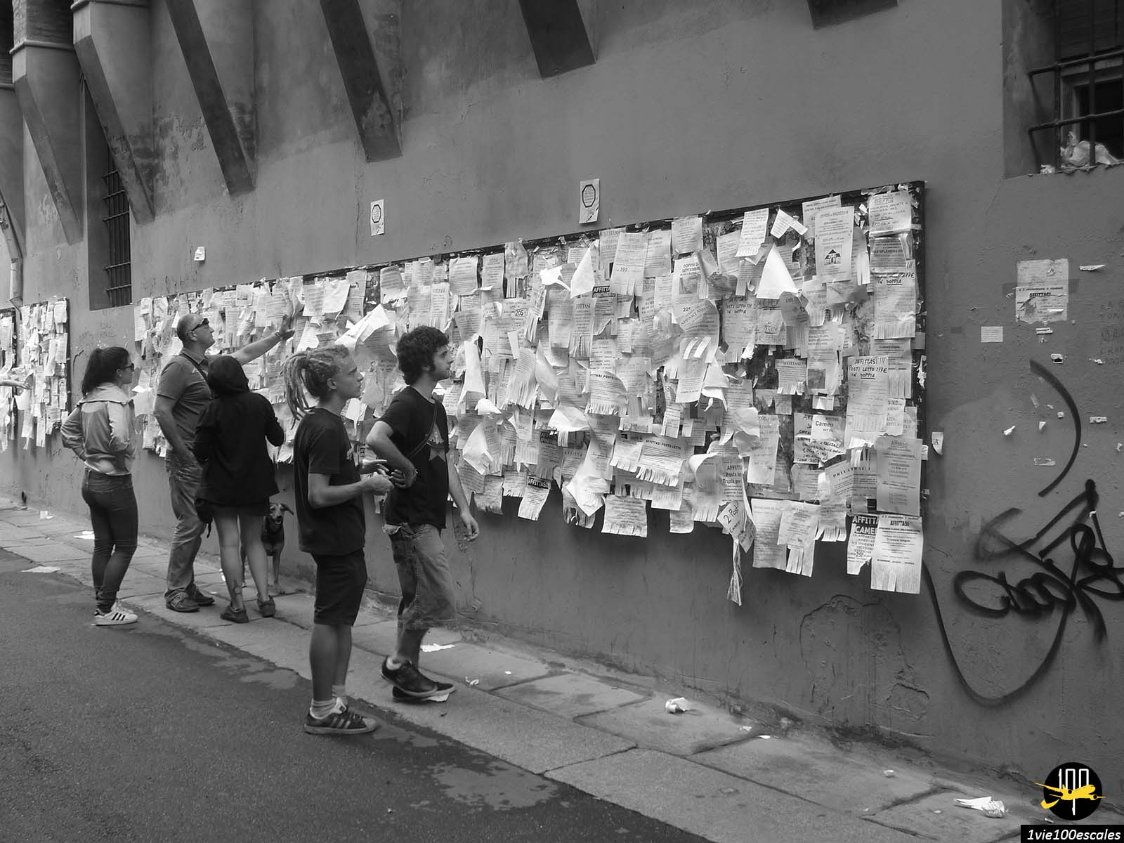 Un groupe de personnes debout près d’un mur couvert de notes.