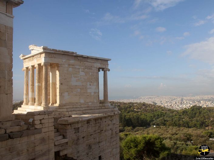 Vue du temple d'Athéna Nike sur l'Acropole d'Athènes, à Athènes en Grèce, surplombant un vaste paysage urbain sous un ciel bleu clair.