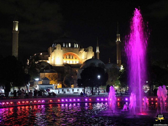 Une vue nocturne de Sainte-Sophie à Istanbul, à Istanbul en Turquie, avec des fontaines roses illuminées au premier plan.