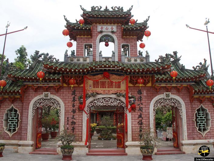 Porte d'entrée ornée d'un temple chinois à Hoi An, au Vietnam, ornée de lanternes rouges, de sculptures complexes et de calligraphies.