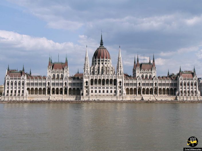 L'image montre le bâtiment du Parlement hongrois, une vaste structure néo-gothique avec un dôme central, s'élevant sur les rives du Danube à Budapest en Hongrie.
