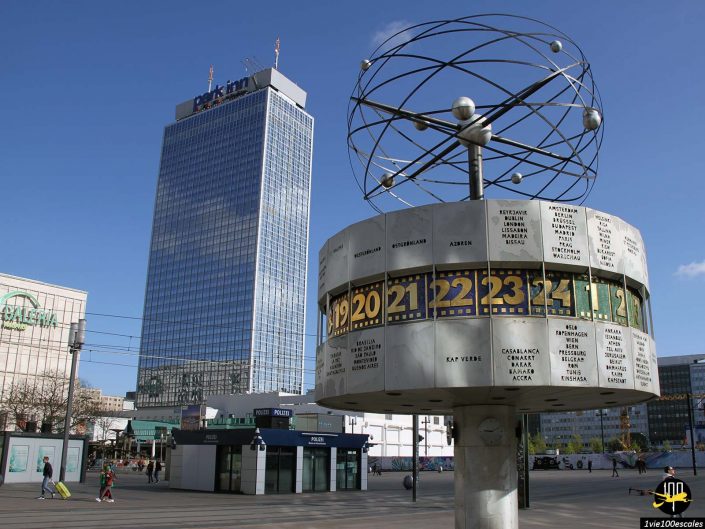 L'image montre l'horloge mondiale sur l'Alexanderplatz, Berlin, à Berlin en Allemagne, avec le bâtiment de l'hôtel Park Inn en arrière-plan sous un ciel bleu clair.