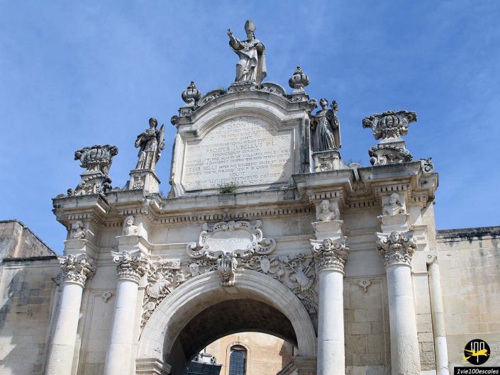 Une arche en pierre avec des statues au sommet à Lecce en Italie.