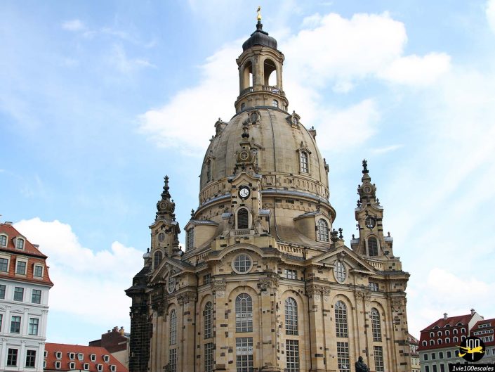 Une vue de la Frauenkirche Dresden, une grande église de style baroque avec un dôme proéminent et des pierres détaillées, sur un ciel bleu avec quelques nuages, à Dresde en Allemagne.