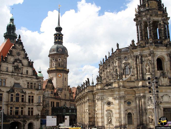 Bâtiments historiques à l'architecture richement ornée à Dresde en Allemagne, dont une haute tour d'horloge avec une flèche pointue, sur un ciel partiellement nuageux.